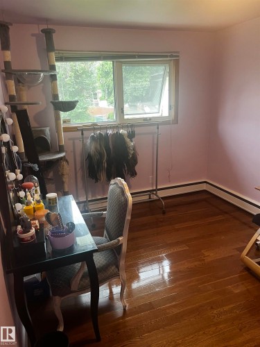 Hardwood flooring, painted walls, and a window providing natural light - 8736 72 Street Nw, Edmonton, AB - Indoor