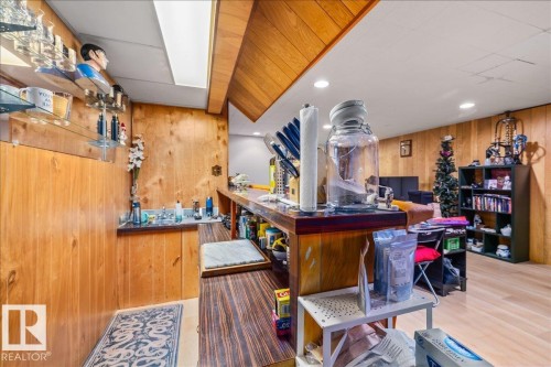 Entertainment space featuring a built-in wet bar with a stainless steel sink and a wood-finish countertop - 8736 72 Street Nw, Edmonton, AB - Indoor Photo Showing Other Room