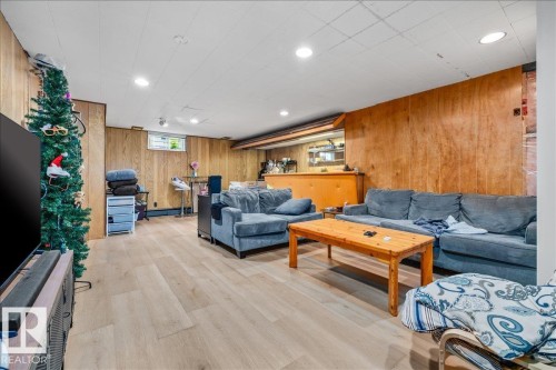 Finished lower level featuring wood-finish flooring, wood paneling, recessed lighting, and a built-in bar area - 8736 72 Street Nw, Edmonton, AB - Indoor