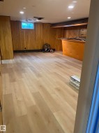 Expansive room featuring light wood-finish flooring, recessed ceiling lighting, and wood paneling - 