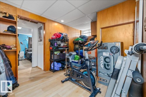 Room with wood-finish flooring, wood paneling, and a drop ceiling - 8736 72 Street Nw, Edmonton, AB - Indoor Photo Showing Other Room