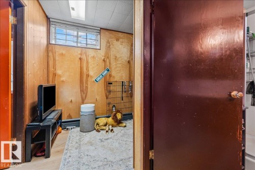 Room featuring wood paneling, a single-pane window, and a drop ceiling with recessed lighting - 8736 72 Street Nw, Edmonton, AB - Indoor