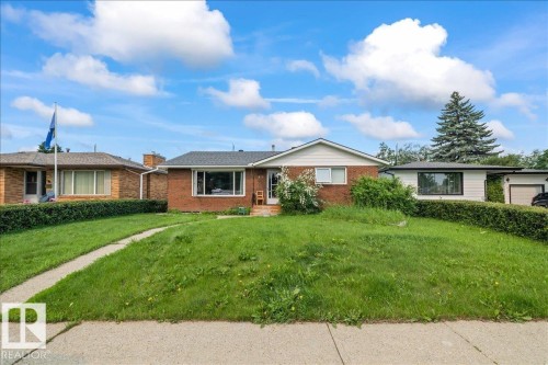 Brick exterior with a gabled roofline and a large picture window - 8736 72 Street Nw, Edmonton, AB - Outdoor