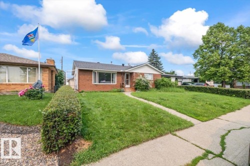 Brick exterior residence featuring a front lawn and paved walkway - 8736 72 Street Nw, Edmonton, AB - Outdoor
