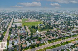 Expansive aerial perspective showcasing a residential neighborhood with numerous single-family homes, mature trees, and paved streets - 