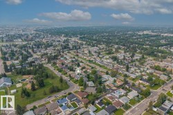 Residential property situated on a corner lot, surrounded by mature trees and paved streets - 