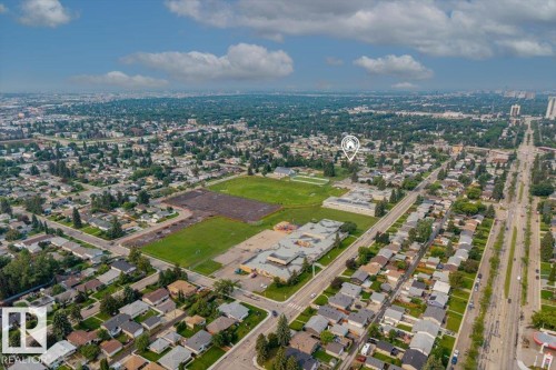 Aerial perspective showcasing a residential neighborhood with tree-lined streets, a large green space, and surrounding urban development - 8736 72 Street Nw, Edmonton, AB - Outdoor With View