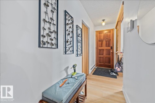 Entryway featuring a paneled wood door, wood-finish flooring, and a ceiling-mounted light fixture - 8736 72 Street Nw, Edmonton, AB - Indoor Photo Showing Other Room
