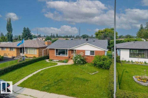 Brick exterior residence featuring a front lawn and a curving paved walkway - 8736 72 Street Nw, Edmonton, AB - Outdoor