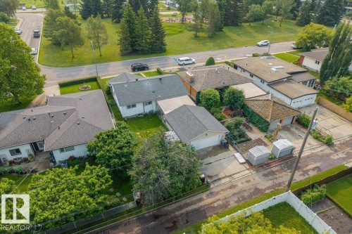 Residential property featuring multiple structures, including a primary residence with a dark shingle roof, an attached garage, and a detached garage with a light shingle roof - 8736 72 Street Nw, Edmonton, AB - Outdoor With View