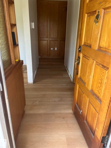 Wood-finish flooring extending from the entryway into the hallway - 8736 72 Street Nw, Edmonton, AB - Indoor Photo Showing Other Room