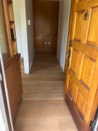 Wood-finish flooring extending from the entryway into the hallway - 