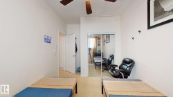 Carpeted interior room featuring a ceiling fan, white paneled door, mirrored closet doors, and recessed lighting - 
