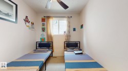 Spacious room featuring neutral painted walls, carpeted flooring, and a ceiling fan - 