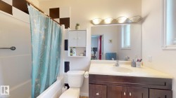 Bathroom featuring a dark wood-finish vanity with a light-toned countertop and an integrated sink - 