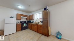 Kitchen featuring wood cabinetry, tiled flooring, white refrigerator, and a window for natural illumination - 