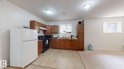 Kitchen area featuring wood cabinetry, laminate countertops, and a white refrigerator - 
