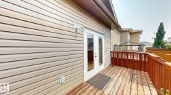 Exterior deck area featuring horizontal siding and a full-light patio door - 
