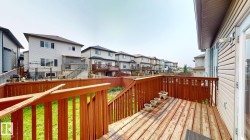 Expansive outdoor deck featuring wood-finish flooring and a full wood railing - 