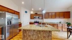 Kitchen featuring a granite-topped island with an undermount sink and gooseneck faucet - 