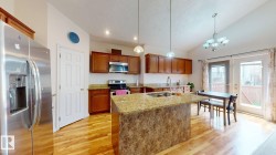 Kitchen featuring wood-finish flooring and a central island with a sink - 