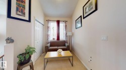 Carpeted room with a double-door closet, a window with blinds, and white trim - 
