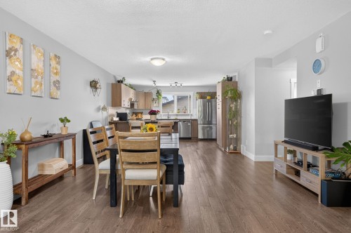Open-concept living area featuring wood-finish flooring and light gray walls - 33 Durrand Bend, Fort Saskatchewan, AB 