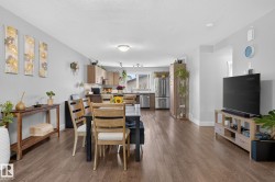 Open-concept living area featuring wood-finish flooring and light gray walls - 