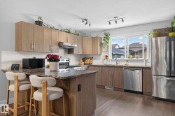 Kitchen featuring granite-style countertops, wood-finish cabinetry, and stainless steel appliances - 
