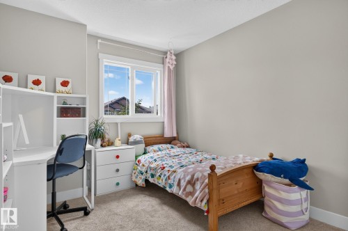 Light-filled room featuring a large window, neutral wall paint, and plush carpet flooring - 33 Durrand Bend, Fort Saskatchewan, AB 