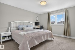Bedroom featuring neutral wall paint, carpet flooring, a window with curtains, and a ceiling-mounted light fixture - 