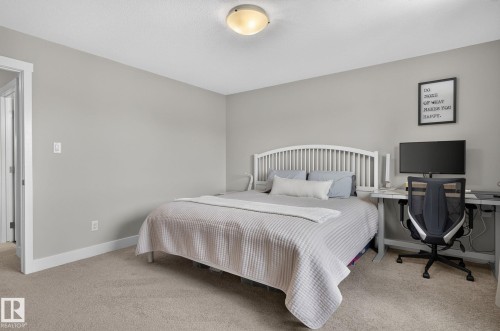 Neutral-toned bedroom featuring carpet flooring and white trim - 33 Durrand Bend, Fort Saskatchewan, AB 