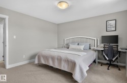 Neutral-toned bedroom featuring carpet flooring and white trim - 