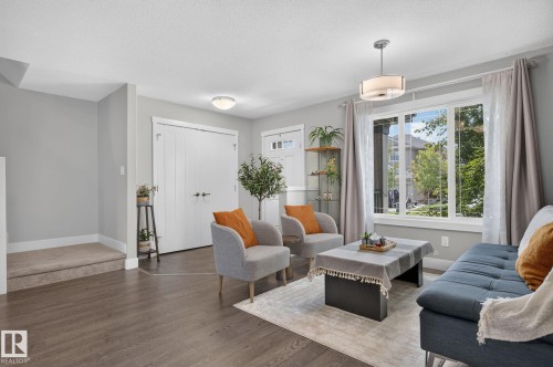 Living area featuring wood-finish flooring, light gray wall paint, and a large multi-pane window - 33 Durrand Bend, Fort Saskatchewan, AB 