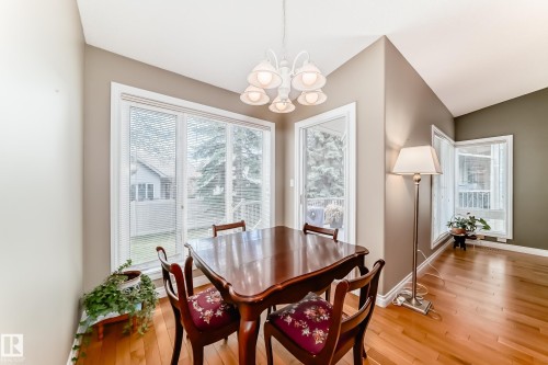 Breakfast nook featuring hardwood flooring, a multi-light chandelier, and large windows with blinds - 29 929 Picard Drive, Edmonton, AB - Indoor Photo Showing Dining Room