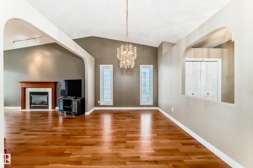 Expansive living area featuring wood-finish flooring and a vaulted ceiling.  Easily expandable for large family gatherings. - 29 929 Picard Drive, Edmonton, AB - Indoor With Fireplace