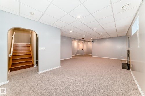Spacious lower-level room featuring light gray walls, plush carpet flooring, and a drop ceiling with recessed lighting - 29 929 Picard Drive, Edmonton, AB - Indoor