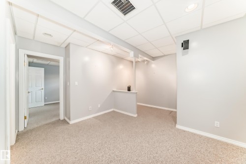 Carpeted interior space featuring a drop ceiling with recessed lighting and a built-in half-wall partition - 29 929 Picard Drive, Edmonton, AB - Indoor Photo Showing Other Room