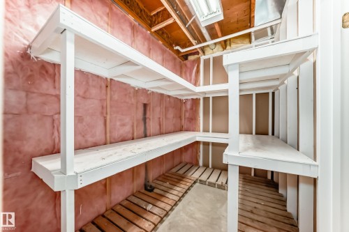 Utility room with extensive built-in shelving, exposed wooden ceiling beams, and concrete flooring - 29 929 Picard Drive, Edmonton, AB - Indoor Photo Showing Other Room