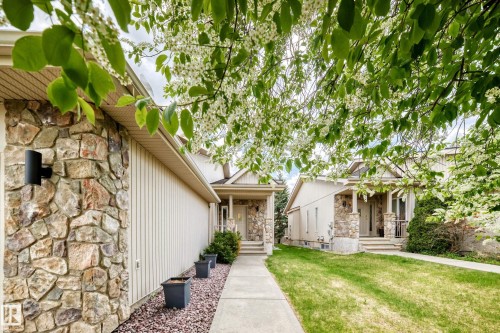 Stone and vertical siding exterior featuring a covered porch with stone columns - 29 929 Picard Drive, Edmonton, AB - Outdoor With Facade
