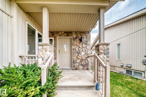 Front entry featuring a stone facade, beige vertical siding, and a covered porch - 29 929 Picard Drive, Edmonton, AB - Outdoor