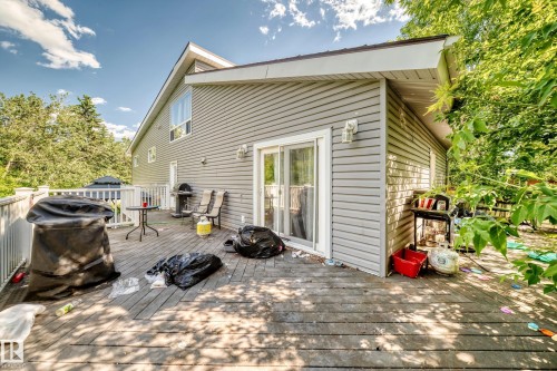 Expansive wooden deck with white railings and direct access to the home via a sliding glass door - 199 Westridge Road, Edmonton, AB 