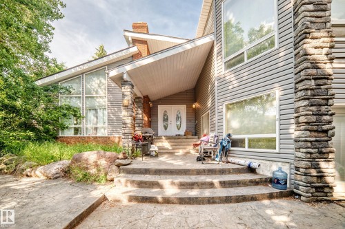 Contemporary exterior featuring horizontal siding and stacked stone accents - 199 Westridge Road, Edmonton, AB 