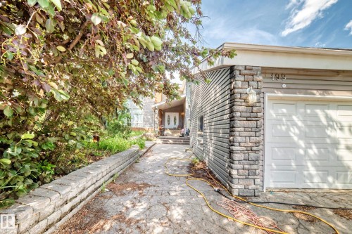 Stone-clad exterior featuring horizontal siding and an integrated garage - 199 Westridge Road, Edmonton, AB 