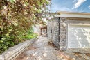 Stone-clad exterior featuring horizontal siding and an integrated garage - 199 Westridge Road, Edmonton, AB 