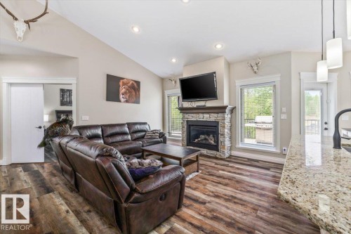 Open-concept living area featuring vaulted ceilings and wood-finish flooring - #6 2406 Twp Road 540, Rural Lac Ste. Anne County, AB - Indoor Photo Showing Living Room With Fireplace