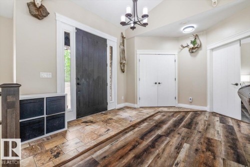 Entryway featuring a dark paneled door with sidelight windows, tile flooring, and wood-finish flooring - #6 2406 Twp Road 540, Rural Lac Ste. Anne County, AB - Indoor