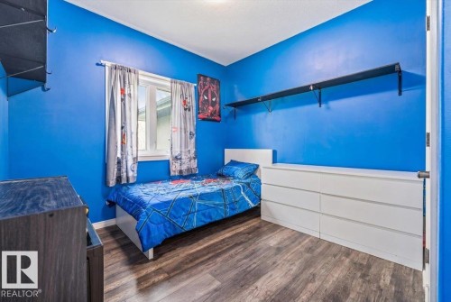 Bedroom featuring wood-finish flooring, a double-paned window, and a built-in wall shelf - #6 2406 Twp Road 540, Rural Lac Ste. Anne County, AB - Indoor Photo Showing Bedroom