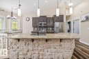 Kitchen featuring a stone-clad island with a granite countertop and an undermount sink - #6 2406 Twp Road 540, Rural Lac Ste. Anne County, AB  - Indoor Photo Showing Kitchen With Double Sink With Upgraded Kitchen 