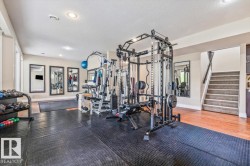 Recreational room with black rubber flooring, recessed lighting, and wall-mounted mirrors - 